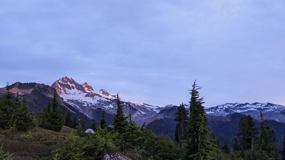 Mount Garibaldi with early morning sun shining on it, and a cloudy sky